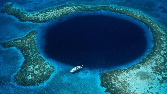 Great Blue Hole, com forma de um círculo perfeito, tem pouco mais de dois quilômetros de largura e atinge 145 metros de profundidadefica. Está localizado próximo da costa de Belize
