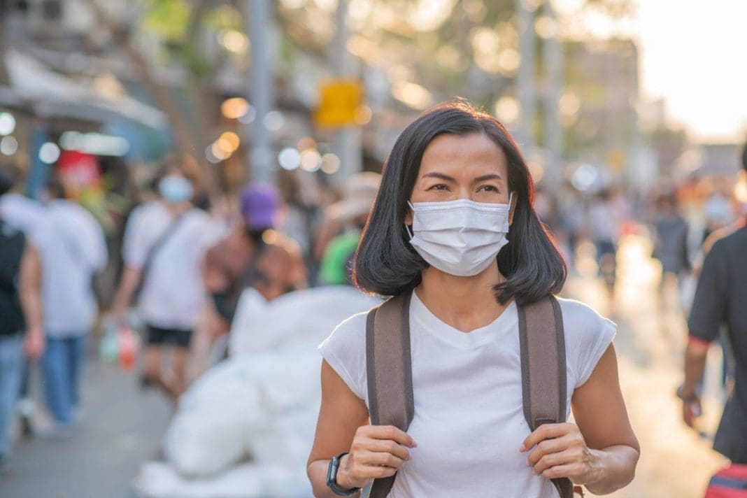 Tourists girls wearing face masks ar street. Happy travel of wom