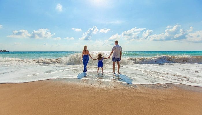 Família de férias na beira da praia foto Natalya Zaritskaya - Unplash