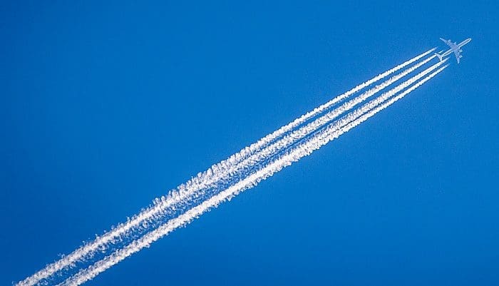 Avião deixa rastro de condensação no céu (foto: William Hock - Unsplash)