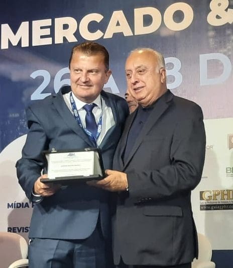 Ranieri Moacir Bertoli recebe prêmio das mãos de Osmar José Vailatti, Presidente do Conselho Deliberativo da ABIH-SC, na abertura do Encatho & Exprotel 2022, em Florianópolis-SC.