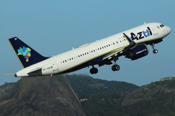 A320NeoAzul_Foto_LuisNeves29 Imagem de um avião A320Neo da Azul decolando. Há um avião no banner do Programa de Estágio Azul 2022.