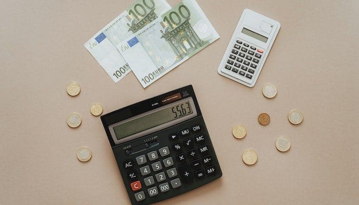 Foto de duas calculadoras, moedas, e notas de euro. Medida Provisória diminuirá o imposto de renda das agências de viagem e outros setores do Turismo.