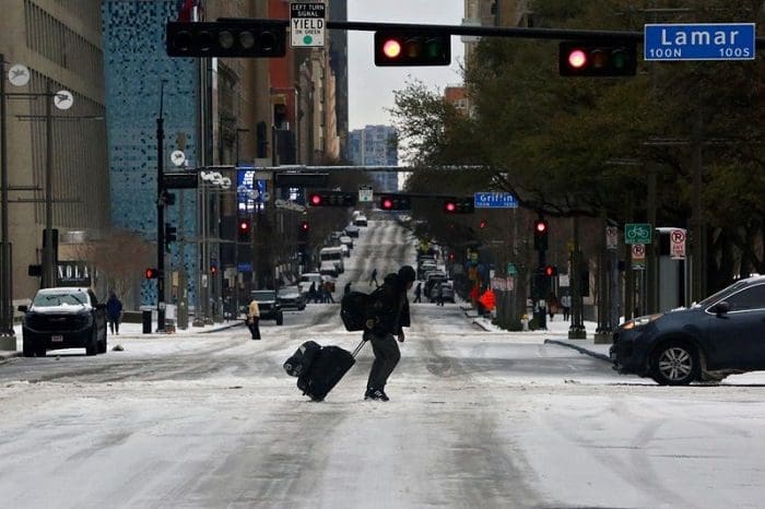 voos_nos_eua_cancelados © Reuters. Pedestre caminha na rua durante passagem de frente fria por Dallas 01/02/2023. Por conta da tempestade, os voos foram cancelados.