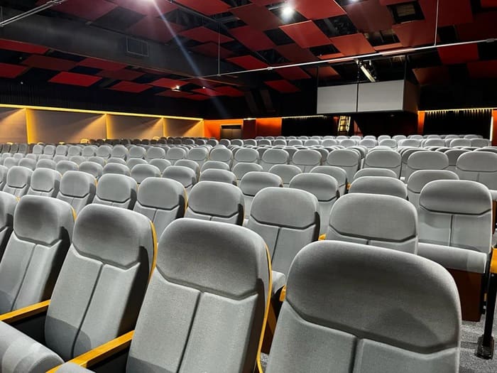 Costao do Santinho inaugura teatro moderno: foto do interior do teatro e das poltronas do local, que são especiais e em tom cinza claro