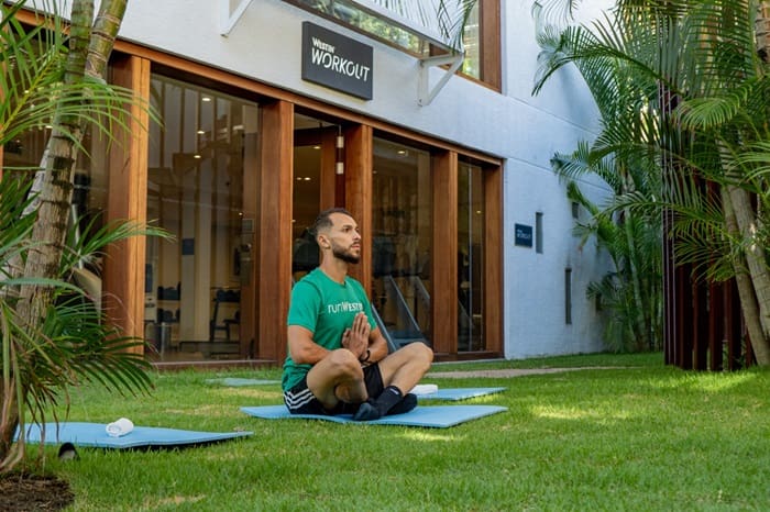 O The Westin Porto de Galinhas terá férias encantadas: rapaz sentado, praticando ioga no resort